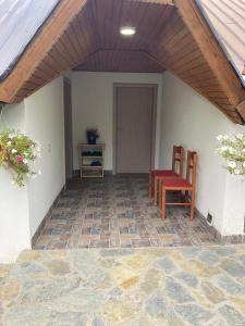 a patio with two chairs and a table and a door at Bujtina Arturi in Valbonë