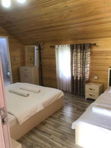 sypialnia z 2 łóżkami i drewnianym sufitem w obiekcie Bujtina Arturi w mieście Valbonë