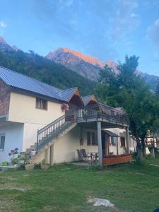 a house with a deck on the side of it at Bujtina Arturi in Valbonë