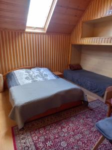 Noclegi u Zosi في Maniowy: غرفة نوم بسريرين في كابينة خشبية