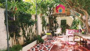 a patio with a table and chairs and trees at Kadmos in Loutra Edipsou