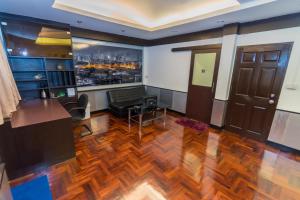a living room with a desk and a television at Flourish Apartments Sukhumvit 39 in Bangkok