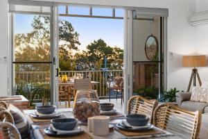a living room with a table and chairs at 3 Bedroom Penthouse - Short Walk to Sandstone Point in Bongaree