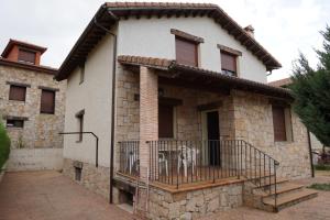 a house with a cow standing on a balcony at Casa la Cabañuela in Navarredonda de Gredos