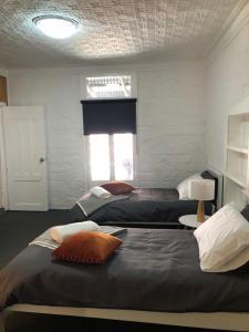 1 dormitorio con 2 camas y ventana con ventana en Black Range Cottage, Tumbarumba en Tumbarumba