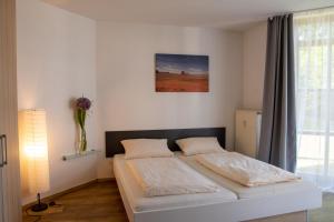 1 dormitorio con 1 cama en una habitación con ventana en Feriendorf Glasgarten, en Rötz
