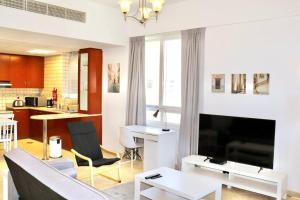 un soggiorno con divano e tavolo di Unified Vacation Homes-Spacious Studio in lush green Motor City a Dubai