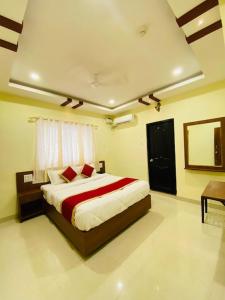a bedroom with a bed with red and white sheets at Prabhuvihar Residency in Porvorim