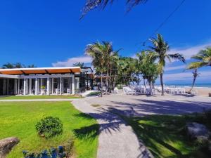 une maison sur la plage avec des palmiers dans l'établissement Chaolao Tosang Beach Hotel, à Chao Lao Beach