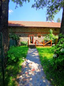 une passerelle menant à un bâtiment en pierre avec une porte dans l'établissement Zabytkowy dom z 2 sypialniami i 2 ogródkami, à Wydminy