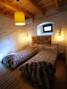 - une chambre avec 2 lits et une fenêtre dans l'établissement Zabytkowy dom z 2 sypialniami i 2 ogródkami, à Wydminy