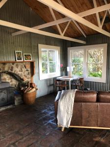 un soggiorno con divano e camino in pietra di Black Range Erin Cottage, Tumbarumba a Tumbarumba