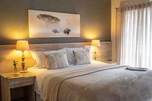 波羅克瓦尼的住宿－Polo Guest House，卧室配有一张白色大床和一张带台灯的桌子