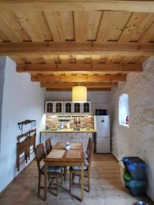 a kitchen with a table and chairs and a refrigerator at Mazurska Sielanka - klimatyczny apartament, 2 sypialnie i 2 ogródki in Wydminy