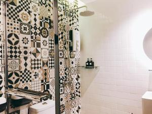 a bathroom with a shower with black and white tiles at Infinity Guesthouse in Semporna
