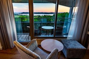 a room with a balcony with a table and chairs at Cliff Hotel Rügen in Ostseebad Sellin