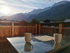 einen Tisch mit zwei Tassen auf einem Balkon mit Bergblick in der Unterkunft Zauscherhof in Wildermieming