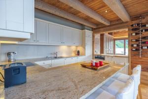 uma cozinha com armários brancos e um tecto de madeira em Chalet Micheline em Riddes