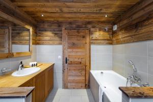 a bathroom with a white tub and a wooden ceiling at Chalet Micheline in Riddes +14 photos