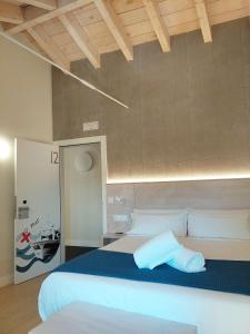 a bedroom with a large bed with a blue blanket at Hotel Tematico Do Banco Azul in Finisterre