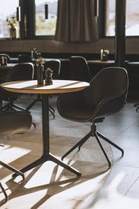 tavolo e sedie in una stanza con tavolo di DAS GERLOS - Boutique Hotel a Gerlos