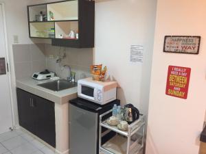 uma pequena cozinha com um lavatório e um micro-ondas em Apartment at Tagaytay Prime Residences em Tagaytay