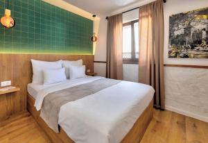 a bedroom with a large bed with a green wall at Hotel Sinan Han in Mostar