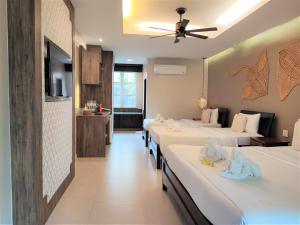 a hotel room with four beds in a room at Samed Villa Resort in Ko Samed
