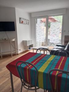 sala de estar con mesa y sillas coloridas en DIGNE LES BAINS, en Digne-les-Bains