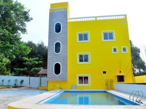 a yellow building with a pool in front of it at SRI SAVERAA RESIDENCY in Pondicherry