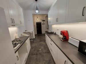 a kitchen with white cabinets and a red appliance at Apartament ultracentral in Oradea