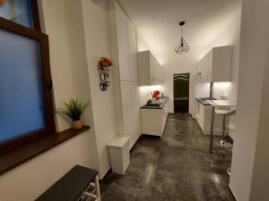 Una cocina con gabinetes blancos y una ventana grande. en Apartament ultracentral, en Oradea