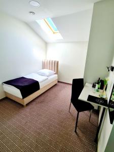 sypialnia z łóżkiem, stołem i krzesłem w obiekcie Via Hotel Polkowice w mieście Polkowice