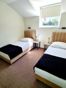 a bedroom with two beds and a window in it at Via Hotel Polkowice in Polkowice