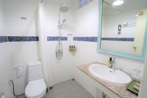a bathroom with a toilet and a sink and a mirror at Samed Villa Resort in Ko Samed