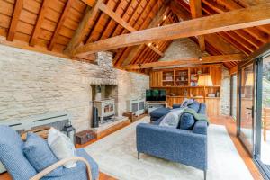 a living room with two blue couches and a fireplace at Barns Lee in Malmesbury