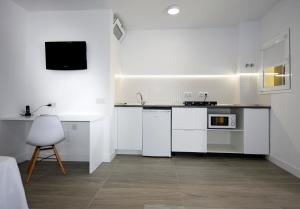 a white kitchen with a sink and a microwave at Skyview Hotel Tenerife in Puerto de la Cruz