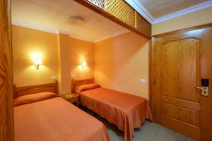 a hotel room with two beds and a door at Skyview Hotel Tenerife in Puerto de la Cruz