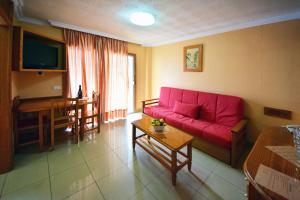 a living room with a red couch and a table at Skyview Hotel Tenerife in Puerto de la Cruz