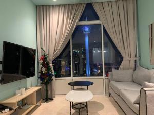 a living room with a couch and a large window at De Sky Suites KLCC Kuala Lumpur in Kuala Lumpur