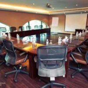einen Konferenzraum mit einem großen Holztisch und Stühlen in der Unterkunft Zara Continental Hotel in Khobar