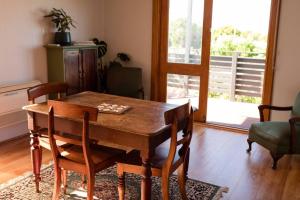 un soggiorno con tavolo e sedie in legno di Little Beach House Bicheno a Bicheno