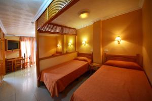 a hotel room with two beds and a television at Skyview Hotel Tenerife in Puerto de la Cruz +9 photos