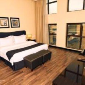 1 dormitorio con 1 cama con reposapiés en Zara Continental Hotel, en Al Khobar