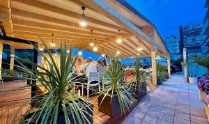 - un balcon avec des tables et des plantes dans l'établissement Hotel Reno, à Lido di Savio