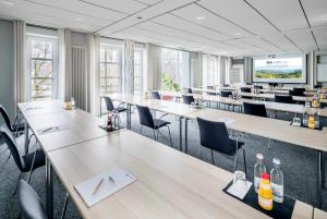 una sala conferenze con tavoli, sedie e schermo per proiezioni di Arberland Tagungshaus a Regen