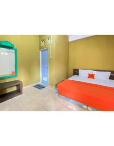 a bedroom with a bed and a flat screen tv at KoolKost Syariah near Stasiun Tanjung Karang Lampung in Bandar Lampung