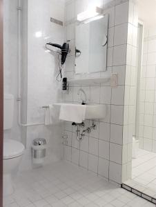 a white bathroom with a sink and a toilet at Hotel-Restaurant-Krone in Bad Brückenau