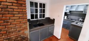 a kitchen with a brick wall and a sink at Alakamandava in Colombo