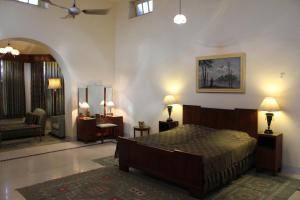 科塔Brijraj Bhawan Palace Hotel的一间带床的卧室和一间客厅